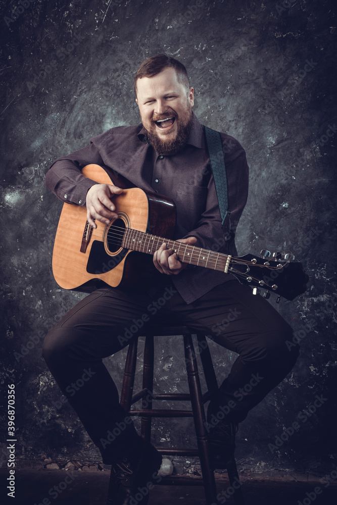 Obraz premium Mature musician plays acoustic guitar emotional studio portrait.
