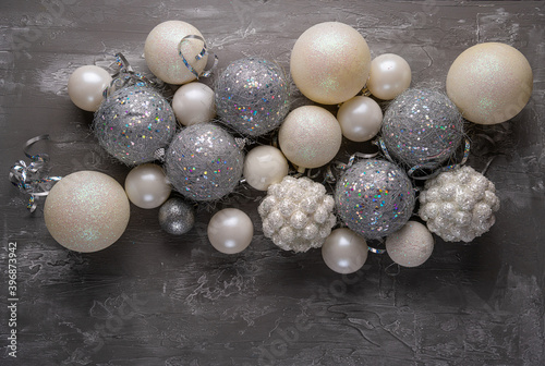 Festive mood, preparation for the holiday. New Year's festive decor in silvery colors - toys, star, round balls, place for an inscription. View from above