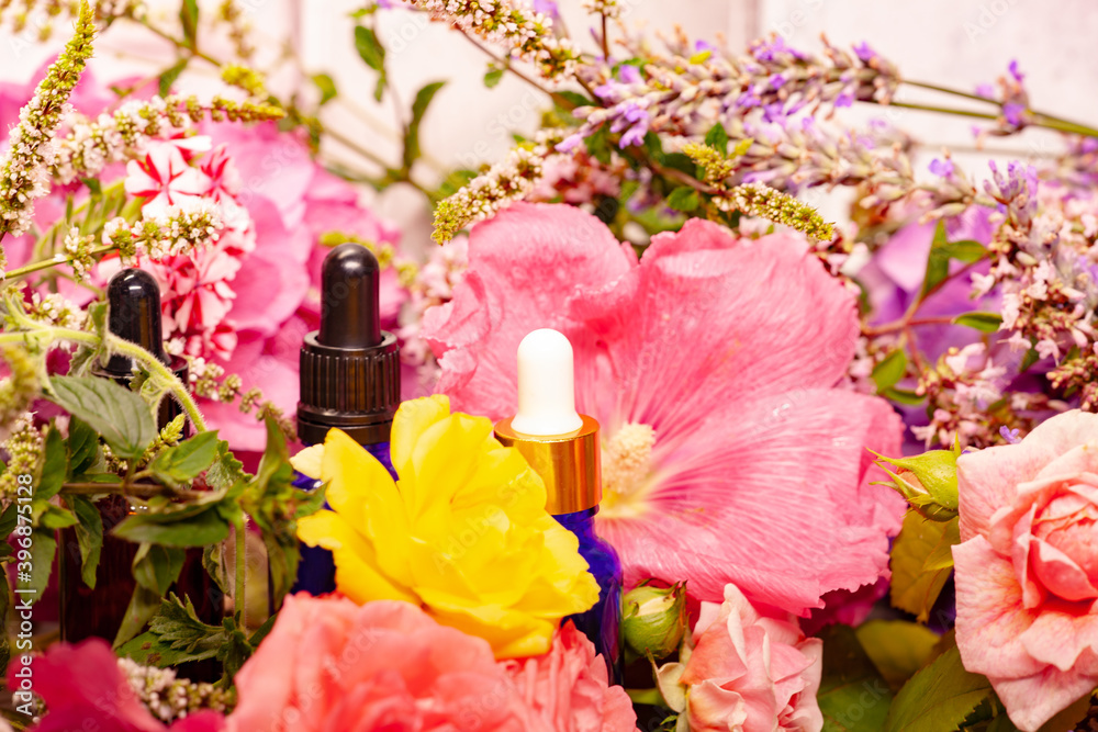 flowers and bottles of essential oils for aromatherapy