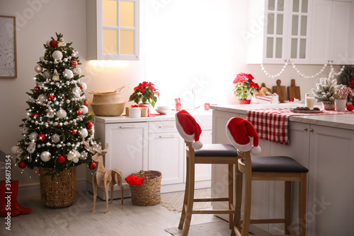 Beautiful kitchen interior with Christmas tree and festive decor