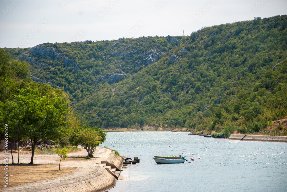 Landscape view of river Zrmanja near city Obrovac, Croatia with two boats in the scene.