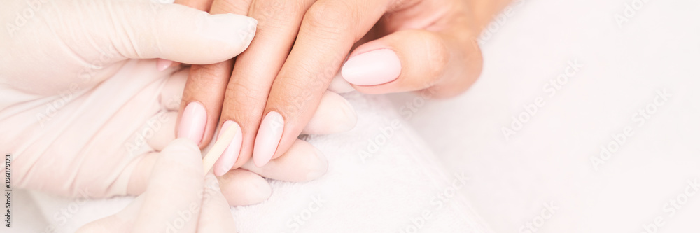 Beautiful salon procedure with pink manicure on towel background. For decoration design. Healthcare. Woman body care. Spa treatment. White background. Nail brush and polish. Apricot stick Beautiful salon procedure with pink manicure on towel background. For decoration design. Healthcare. Woman body care. Spa treatment. White background. Nail brush and polish. Apricot stick
