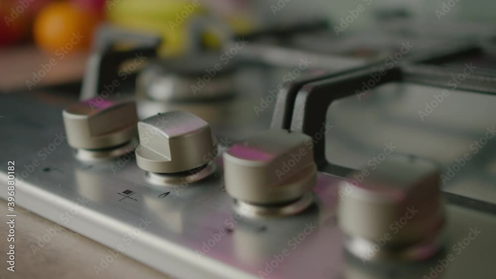Hand twist knob on modern gas stove. Man turn temperature on oven button. Hand twist knob on modern gas stove. Man turn temperature on oven button.