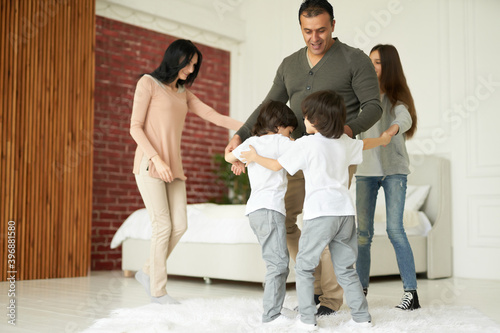 Happy together. Full length shot of beautiful latin family having fun indoors. Mom and dad playing with their children at home