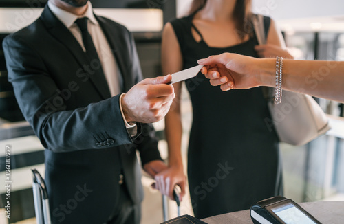 Business people makes card payment at check-in at reception.