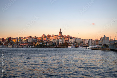 By Eminonu district of Istanbul, fishing and people walking on the Galata bridge and fishing, ferry carrying passengers and Galata Tower views