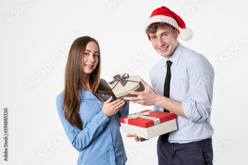 Happy couple in santa claus hat hold present gift box, isolated over white