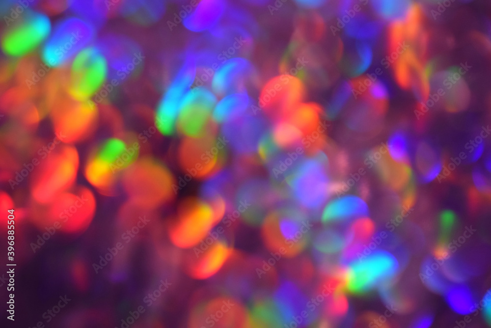 Christmas background, garland in blur. Glowing and festive rainbow light circles created in camera and bokeh lens. Christmas fairy lights are defocused giving a blurry effect. Christmas background, garland in blur. Glowing and festive rainbow light circles created in camera and bokeh lens. Christmas fairy lights are defocused giving a blurry effect.