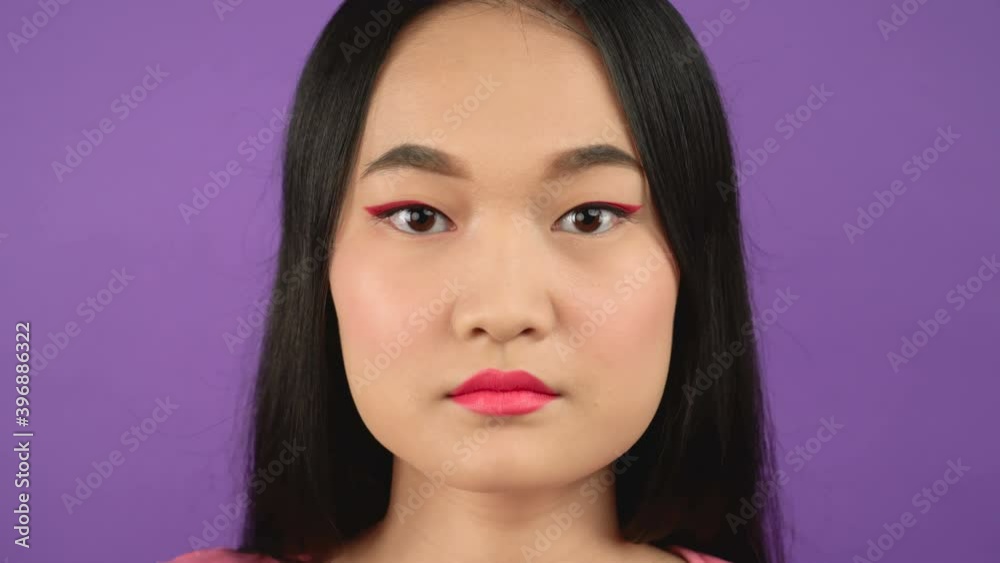 close-up portrait of young asian woman on isolated purple background 4K close-up portrait of young asian woman on isolated purple background 4K