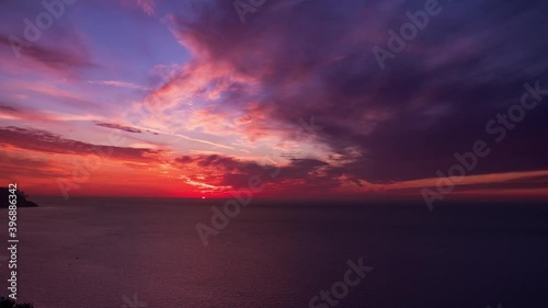 spectacular sunset hyperlapse on the sea with cloudy twilight sky and cliffs coastline. timelapse of sunset from sa foradada viewpoint in mallorca island with epic panorama photo