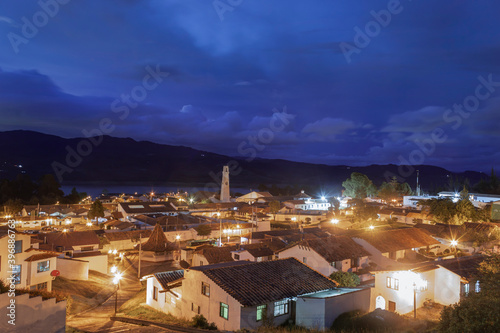 Colombian Guatavita colonial town night cityscape with colonial architecture and city lights with andean mountains and blue evening sky at background. Travel concept © Alejandro Bernal