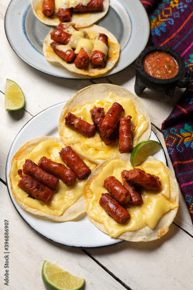 Mexican chistorra tacos with cheese on white background