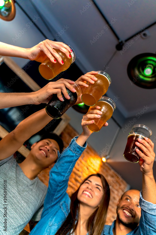 Obraz premium A group of friends toasting in a pub