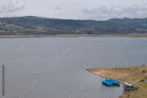 GUATAVITA, COLOMBIA - Tomine Lake at sunny morning with mountains and grey sky photo