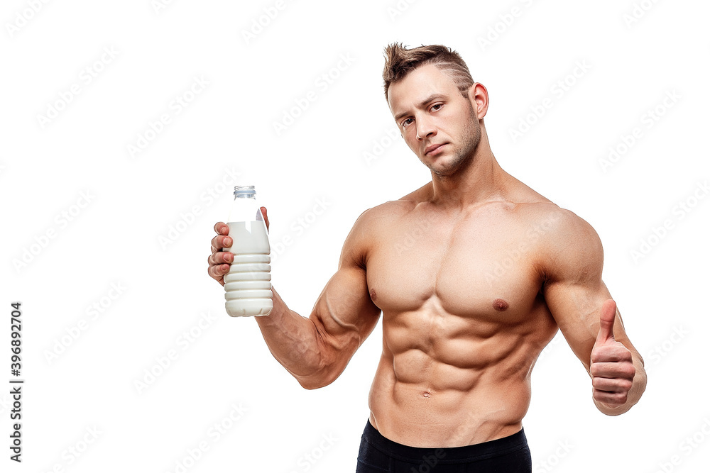 a bottle of milk in his hand, a man with sporty body posing on a white background. a bottle of milk in his hand, a man with sporty body posing on a white background.