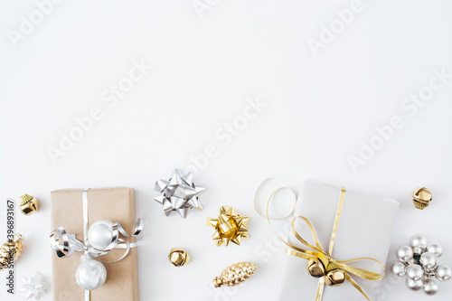 Christmas presents and gifts and gold and silver decorations on white background. Merry christmas, New Year holiday concept. Flat lay, top view, copy space.