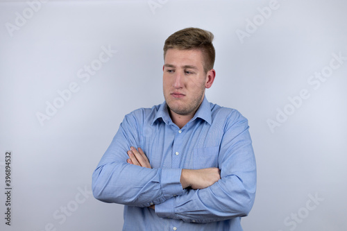 Business young man wearing a casual shirt over white background thinking looking tired and bored with crossed arms