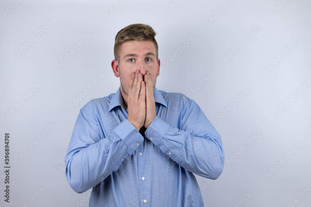 Business young man wearing a casual shirt over white background with her hands over her mouth and surprised Business young man wearing a casual shirt over white background with her hands over her mouth and surprised