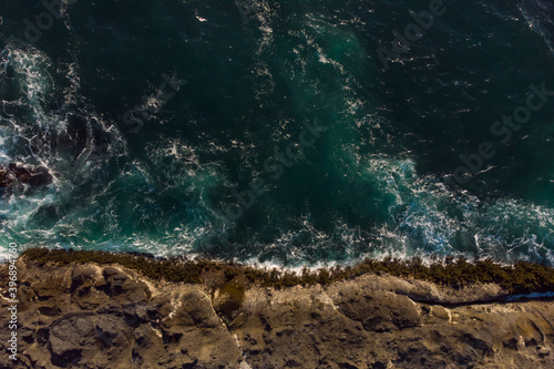 Aerial view of ocean waves and fantastic rocky coast. Wallpaper design. Amazing landscape. View from above.