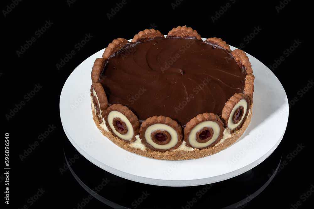 Dutch pie Topped with dark chocolate ganache on a white wooden base over dark glass