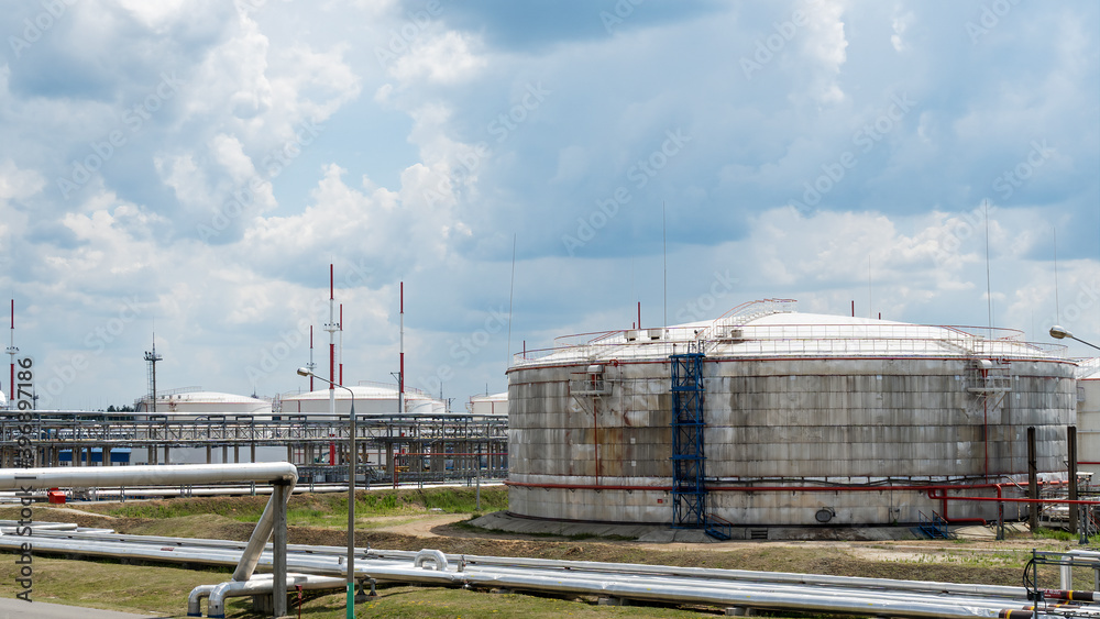 Obraz premium Refinery process area of petrochemical plant on classic blue sky with clouds background. Oil refining concept.