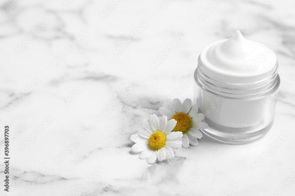Chamomile flowers and jar of cream on white marble table. Space for text Chamomile flowers and jar of cream on white marble table. Space for text