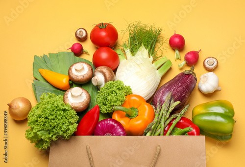Different fresh vegetables on yellow background  flat lay