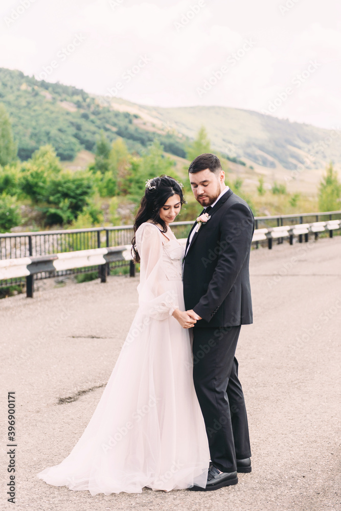 Walk the newlyweds in nature against the backdrop of wooded mountains