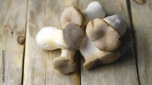 Fresh eringi mushrooms on a wooden surface.