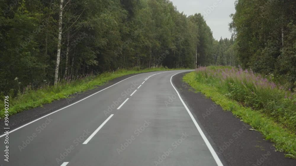Driving along an empty road among the forest in cloudy weather. Driving along an empty road among the forest in cloudy weather.