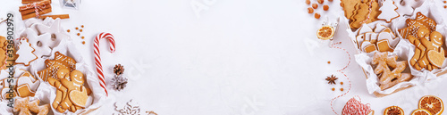 Top view of unpacked christmas presents with sweets on a white textured surface, banner, close-up. Christmas celebration concept with space for text