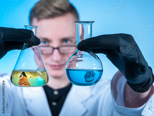 Chemist with two flasks. Th...