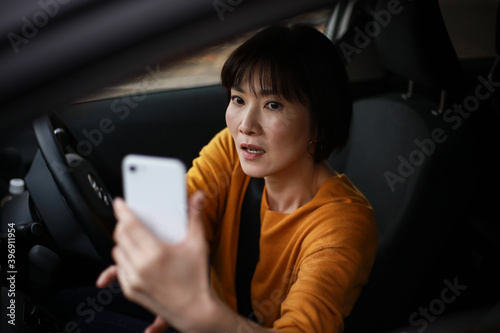 慌ててスマートフォンで撮影する女性 © yamasan