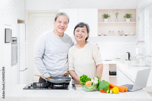 Smiling old couple cooking in the kitchen