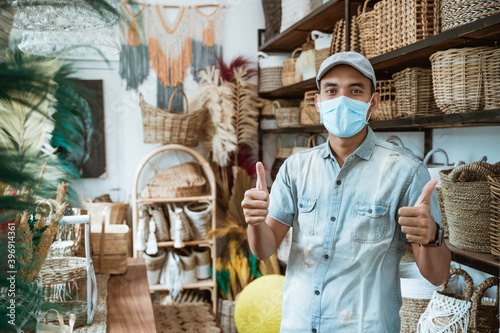 male business owner keep working and wear face masks at his art and craft store photo