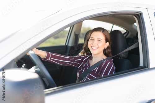Pretty female driver smiling and driving on the highway