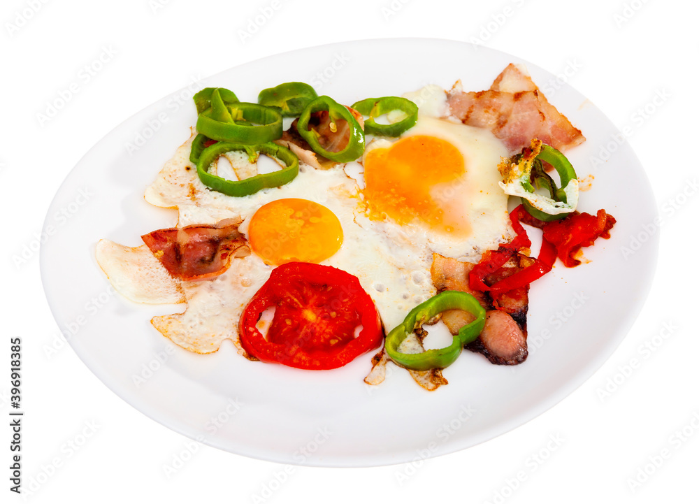 Breakfast dish - scrambled eggs with bacon and vegetables. Isolated over white background