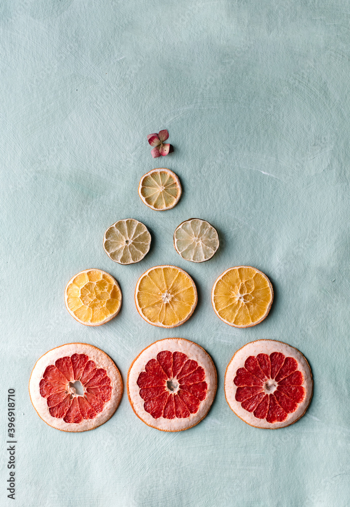 Dried citrus slices in the shape of a Christmas tree top view on a blue background. Christmas or New Year. Copy space. Dried citrus slices in the shape of a Christmas tree top view on a blue background. Christmas or New Year. Copy space.