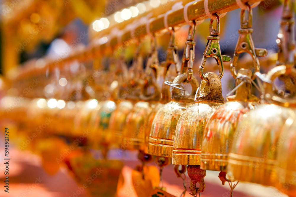 Obraz premium Closeup and perspective view group of small golden bells hang in Thai temple on blurry background.