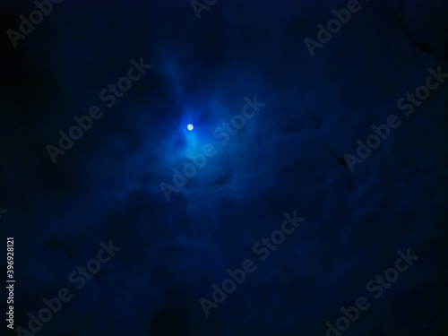 Fototapeta Naklejka Na Ścianę i Meble -  Mystic Moon Hangs in Swirl of Clouds in Night Darkness