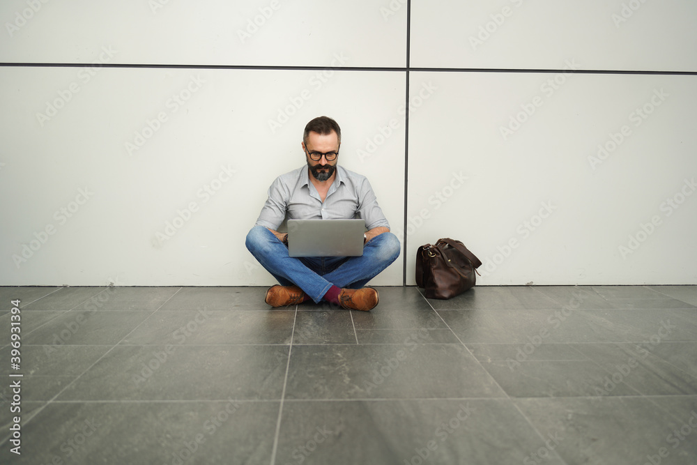 Lifestyle of man hipster freelancer standing and holding laptop at office terminal corporate, professional freelance man concept Lifestyle of man hipster freelancer standing and holding laptop at office terminal corporate, professional freelance man concept