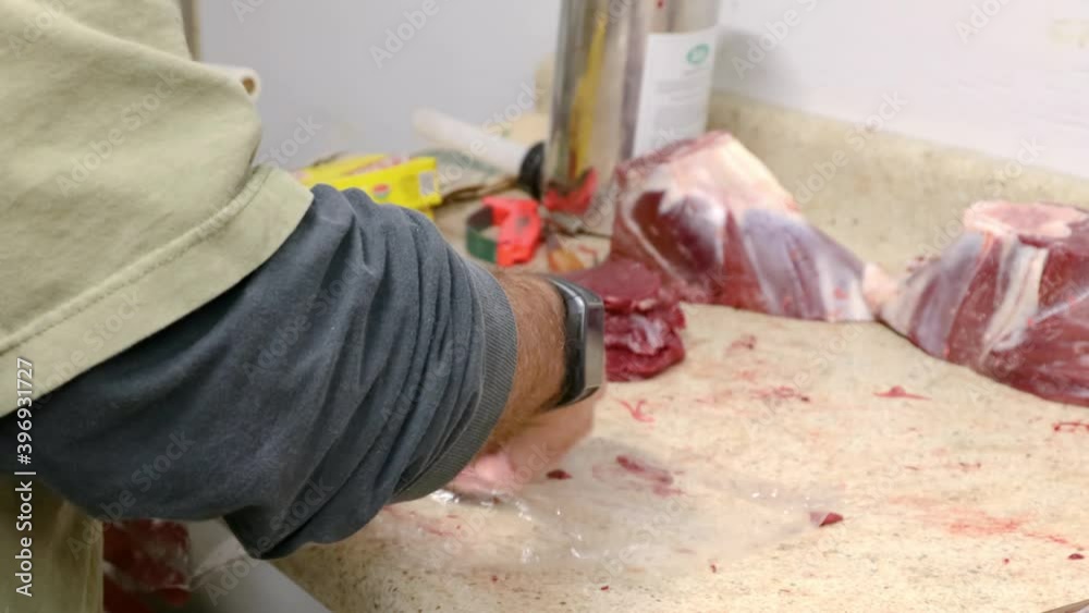 Hunter processing wild game; preparing to freeze venison steaks by wrapping the steaks in plastic wrap Hunter processing wild game; preparing to freeze venison steaks by wrapping the steaks in plastic wrap