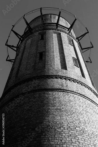 An old brick water tower built in the 1900s, now unused. Low angle shot looking up. Black and white. Photographed in Cambridge, New Zealand photo