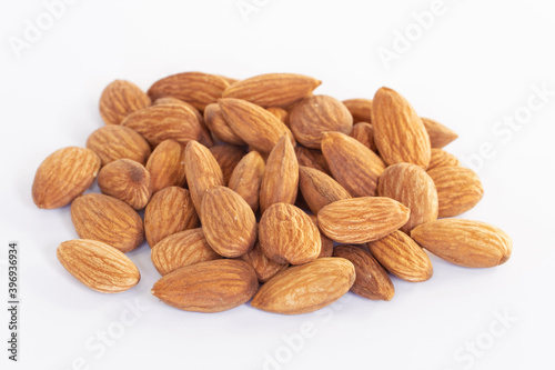 Pile of almonds seeds isolated on white background. Focus closeup group of nuts.