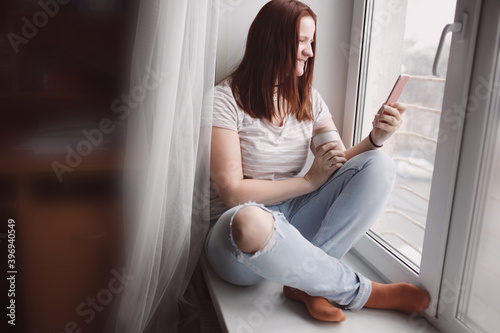 Free Download plus size caucasian woman at the window with a phone, chatting and talking on video. Gadgets and communication concept, live broadcast on social network - GFXLoad