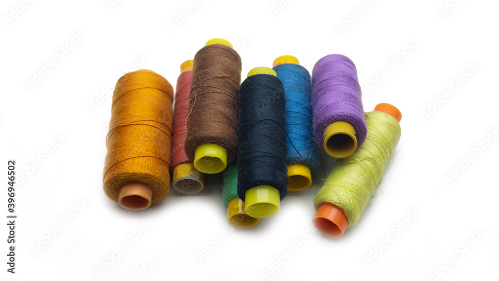 A various colors of sewing thread roll on an isolated white background. A various colors of sewing thread roll on an isolated white background.