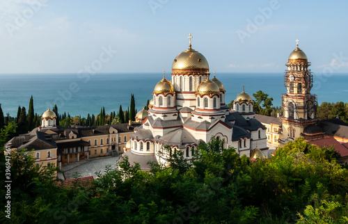 Graceful, beautiful and sunny Male Simon the Conanite monastery with golden domes against the backdrop of the endless blue sea. New Byzantine style 1875. New Athos, Abkhazia.