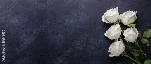 Fotografia Horizontal banner with white rose flowers bouquet on black stone background