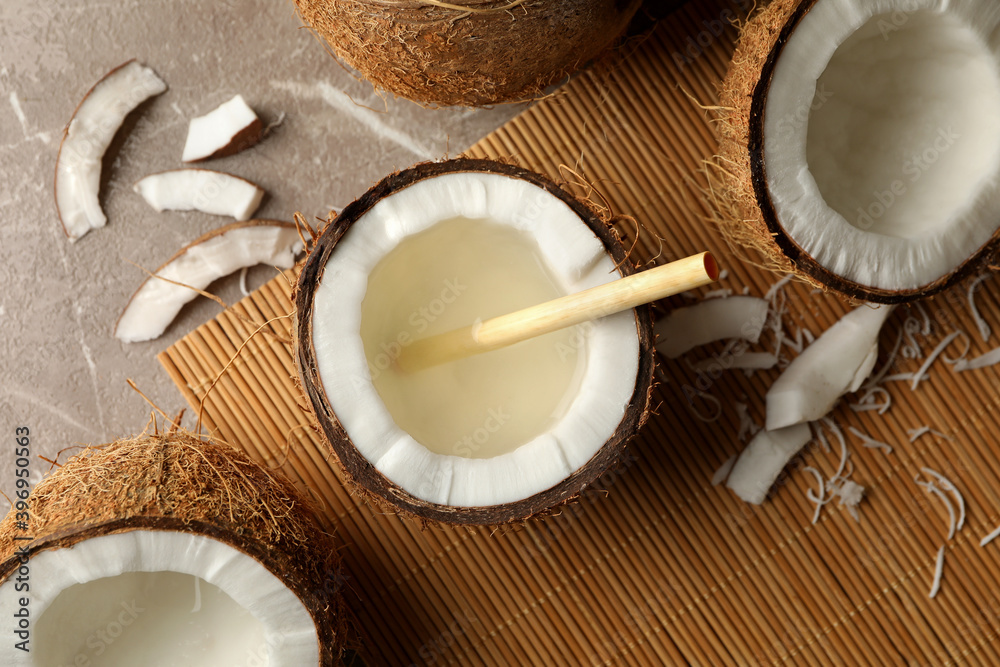 Tasty coconut with straw on bamboo background Tasty coconut with straw on bamboo background