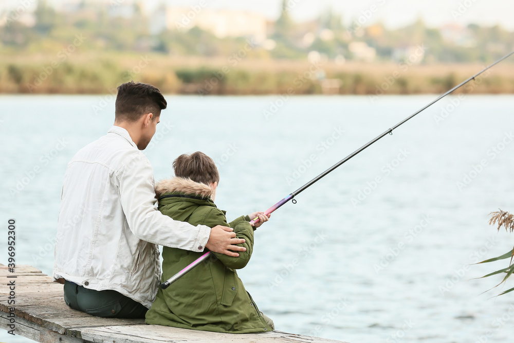 Little boy and his father fishing on river Little boy and his father fishing on river